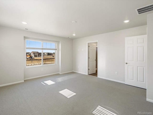 carpeted empty room featuring visible vents, recessed lighting, and baseboards