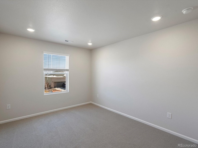 carpeted empty room featuring recessed lighting, visible vents, and baseboards