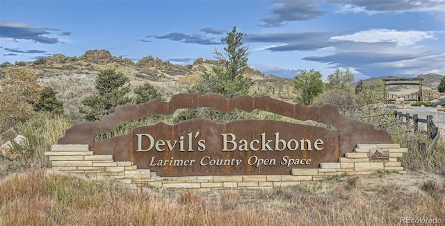 community / neighborhood sign with a mountain view