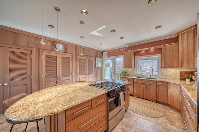 224 W Warren Ave, Cripple Creek, CO 80813 - kitchen with stainless steel gas range, tasteful backsplash, a sink, ornamental molding, and light stone counters