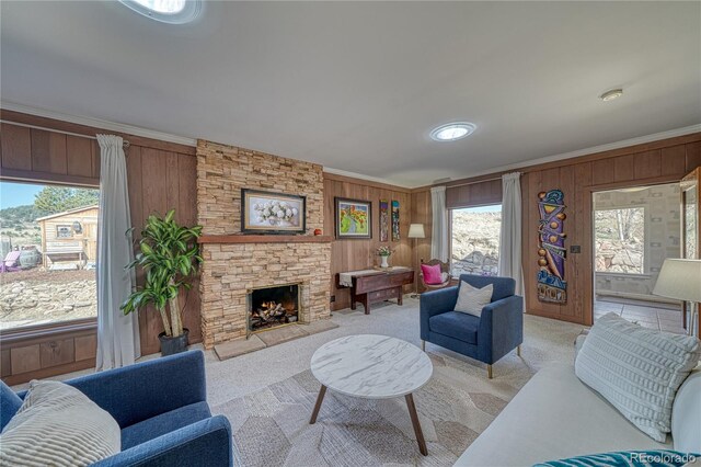 224 W Warren Ave, Cripple Creek, CO 80813 - living room with wood walls, crown molding, light colored carpet, plenty of natural light, and a stone fireplace