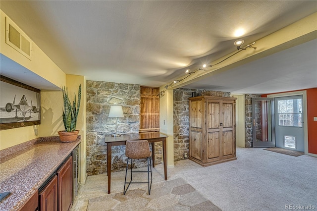 224 W Warren Ave, Cripple Creek, CO 80813 - kitchen with light colored carpet, dark countertops, and beverage cooler
