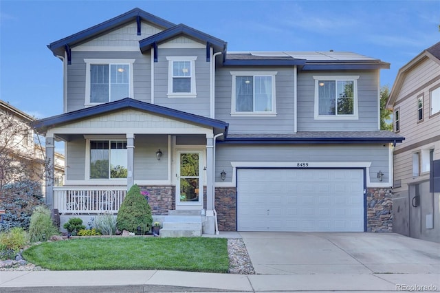 8489 S Quay St, Littleton, CO 80128 - craftsman inspired home featuring an attached garage, driveway, covered porch, and stone siding