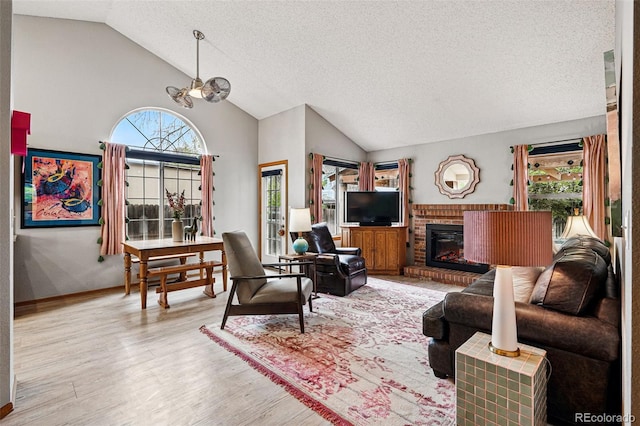 13313 Cherry Cir, Thornton, CO 80241 - living room with vaulted ceiling, wood finished floors, a textured ceiling, a fireplace, and a chandelier