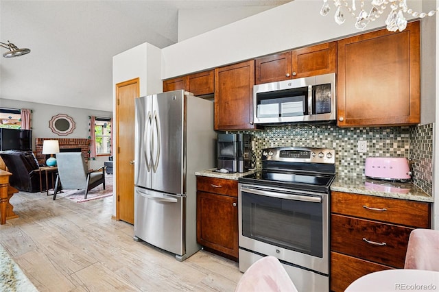 13313 Cherry Cir, Thornton, CO 80241 - kitchen with stainless steel appliances, light wood-style flooring, backsplash, open floor plan, and light stone counters