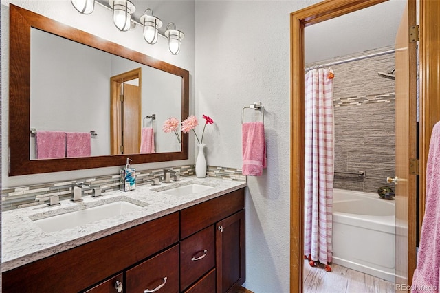 13313 Cherry Cir, Thornton, CO 80241 - bathroom featuring double vanity, a textured wall, shower / bath combination with curtain, and wood finished floors