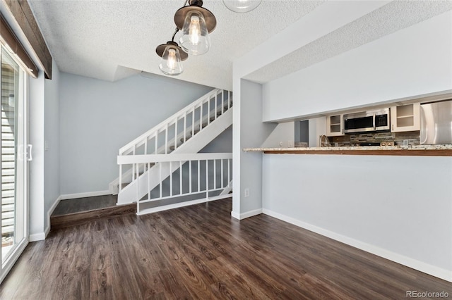 6011 Yarrow St Unit I, Arvada, CO 80004 - unfurnished living room featuring wood finished floors, stairs, and a textured ceiling