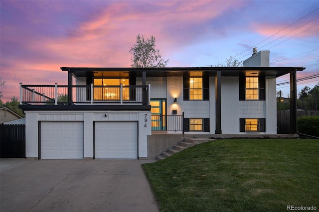 view of front of house featuring a balcony, driveway, a chimney, and an attached garage