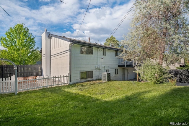 rear view of house with a chimney, cooling unit, and a deck