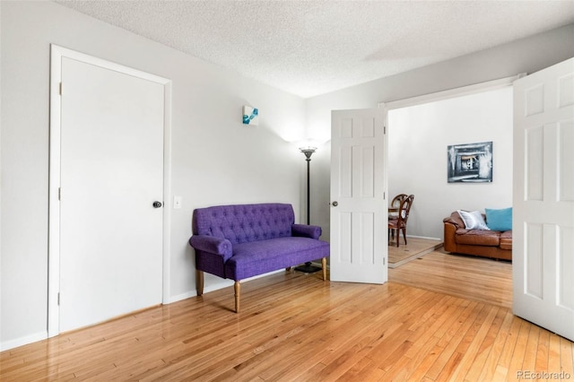 sitting room with wood-type flooring and a textured ceiling