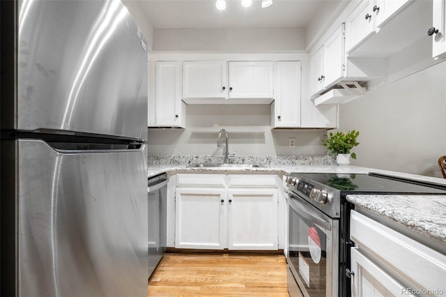 kitchen with appliances with stainless steel finishes, sink, and white cabinets