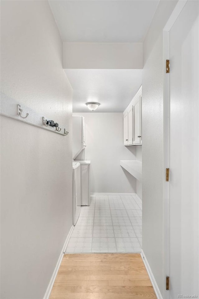 corridor with washer / dryer and light wood-type flooring