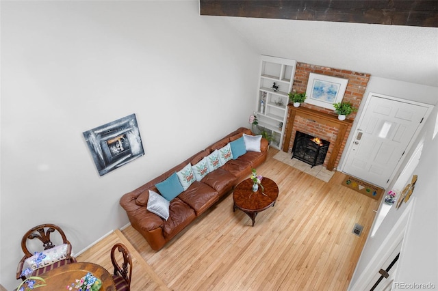 living room featuring hardwood / wood-style flooring and a brick fireplace