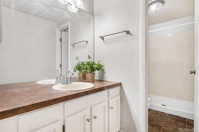 bathroom with walk in shower, vanity, toilet, and tile patterned flooring