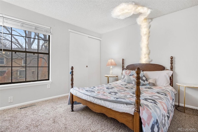 carpeted bedroom featuring a closet and a textured ceiling