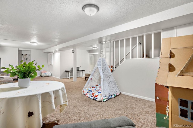 game room with a textured ceiling and carpet