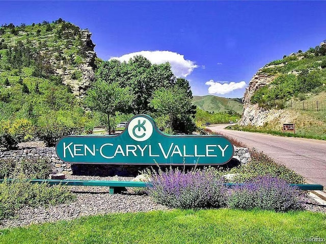 community / neighborhood sign with a mountain view