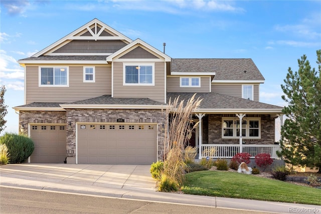 craftsman-style house featuring a front yard, driveway, roof with shingles, covered porch, and brick siding