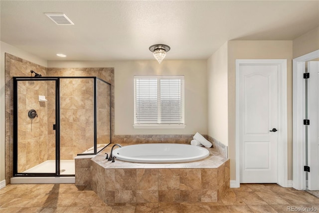 bathroom with visible vents, a shower stall, and a garden tub