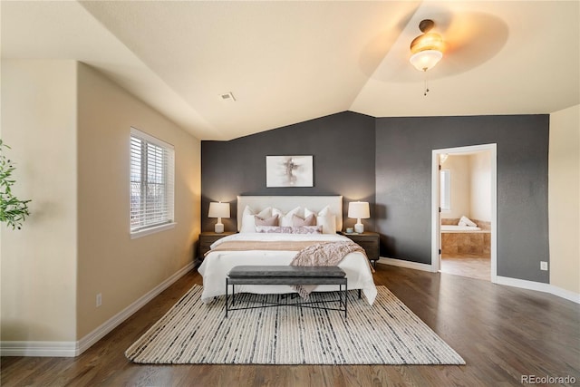 bedroom with connected bathroom, baseboards, lofted ceiling, and wood finished floors