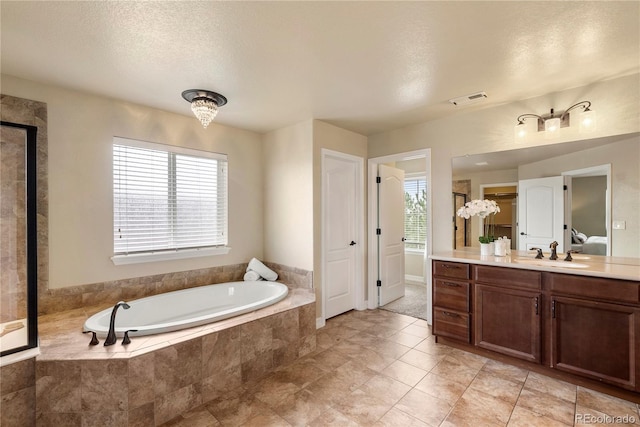 bathroom featuring visible vents, walk in shower, vanity, a bath, and a textured ceiling