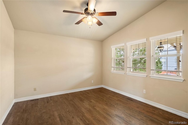 spare room with dark wood-style floors, visible vents, baseboards, lofted ceiling, and ceiling fan