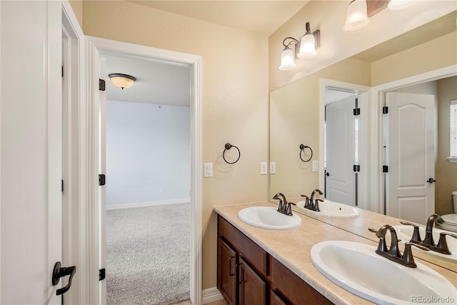 bathroom with double vanity, baseboards, and a sink