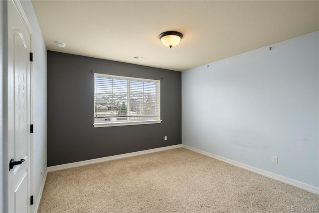 carpeted empty room with visible vents and baseboards