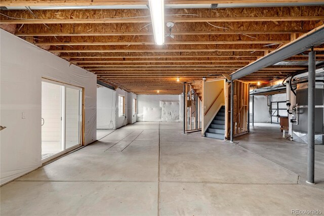 basement with stairway and heating unit