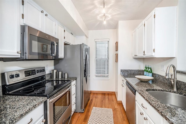 kitchen featuring a sink, light wood-style flooring, white cabinets, and stainless steel appliances