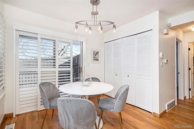 dining space with visible vents and light wood-style flooring