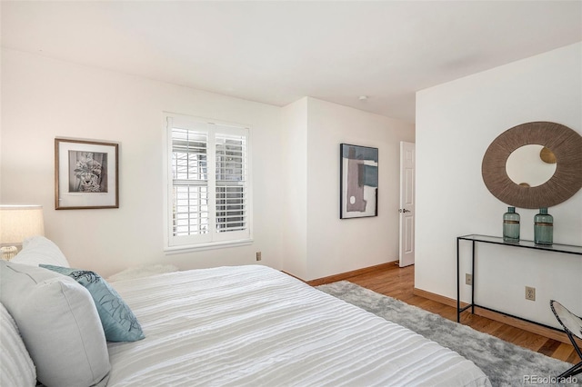 bedroom featuring baseboards and wood finished floors