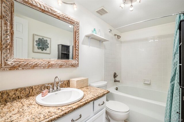 bathroom featuring visible vents, vanity, toilet, and shower / tub combo