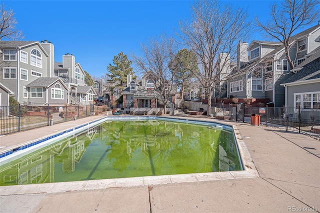 view of swimming pool featuring a fenced in pool, fence, and a residential view