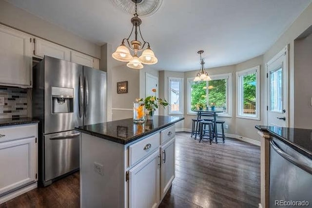 7176 S Pierson St, Littleton, CO 80127 - kitchen featuring appliances with stainless steel finishes, a chandelier, dark wood-style flooring, white cabinetry, and a center island
