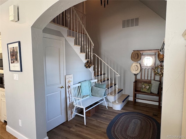 stairway featuring hardwood / wood-style flooring and a towering ceiling