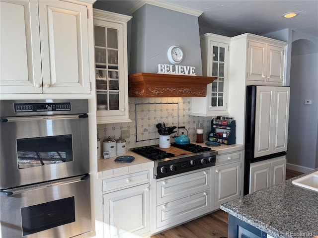 kitchen with white cabinetry, decorative backsplash, dark wood-type flooring, and appliances with stainless steel finishes