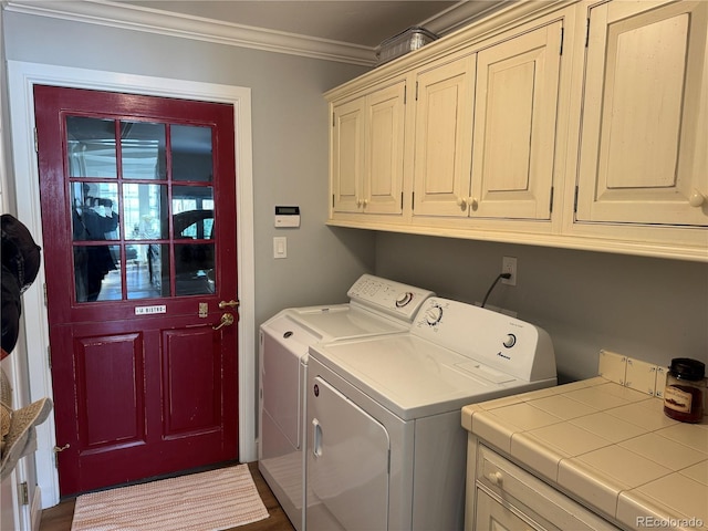 laundry room with washer and clothes dryer, ornamental molding, and cabinets