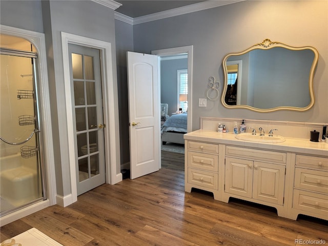 bathroom featuring vanity, hardwood / wood-style flooring, ornamental molding, and walk in shower