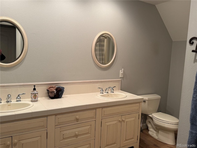 bathroom with vanity, hardwood / wood-style floors, vaulted ceiling, and toilet