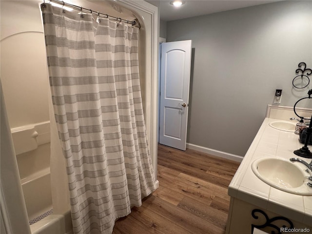 bathroom with vanity, wood-type flooring, and shower / bath combo with shower curtain