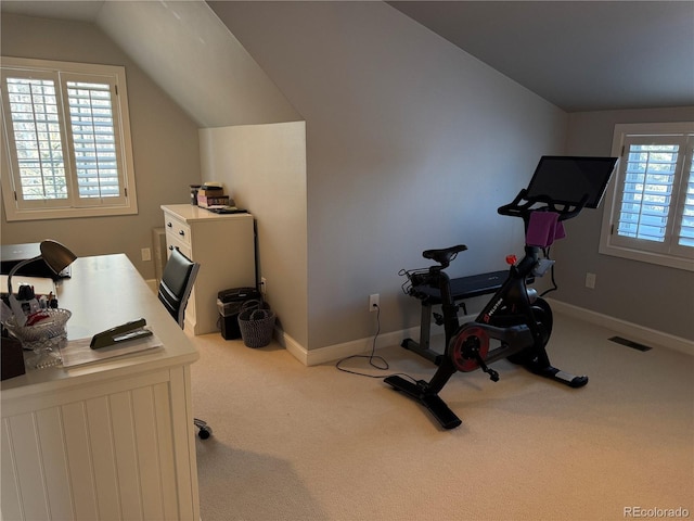 carpeted home office with vaulted ceiling