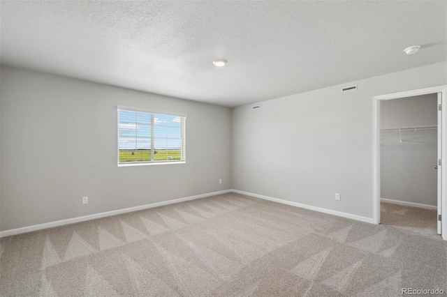 7322 Green River Ave, Frederick, CO 80530 - unfurnished bedroom with carpet flooring, baseboards, a spacious closet, a textured ceiling, and a closet