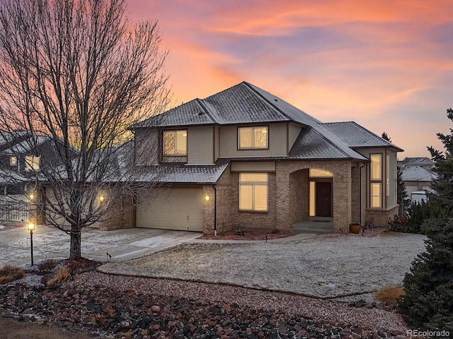 view of front facade featuring a garage, concrete driveway, and brick siding