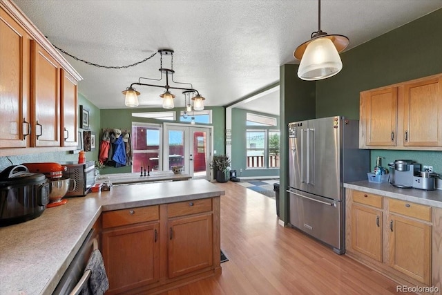 3316 Carlson Rd, Rye, CO 81069 - kitchen with high end refrigerator, a peninsula, light wood-type flooring, light countertops, and a textured ceiling