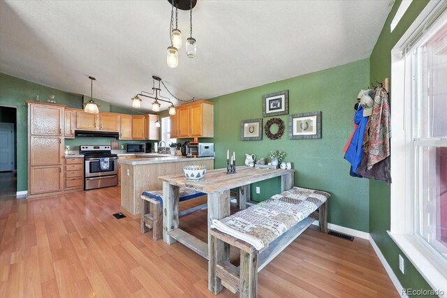 3316 Carlson Rd, Rye, CO 81069 - kitchen featuring stainless steel electric range, black microwave, healthy amount of natural light, light brown cabinets, and vaulted ceiling