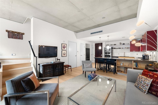 living room featuring sink and light hardwood / wood-style flooring