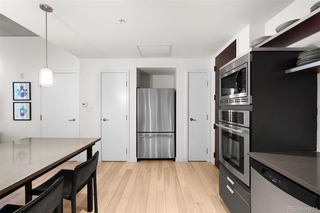 kitchen with pendant lighting, light hardwood / wood-style flooring, and appliances with stainless steel finishes