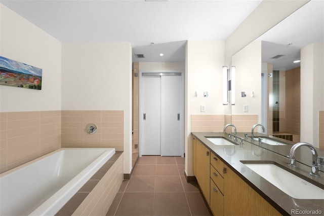 bathroom featuring vanity, backsplash, tile patterned floors, and independent shower and bath