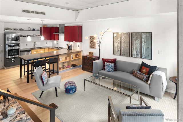 living area featuring light wood-style flooring and visible vents
